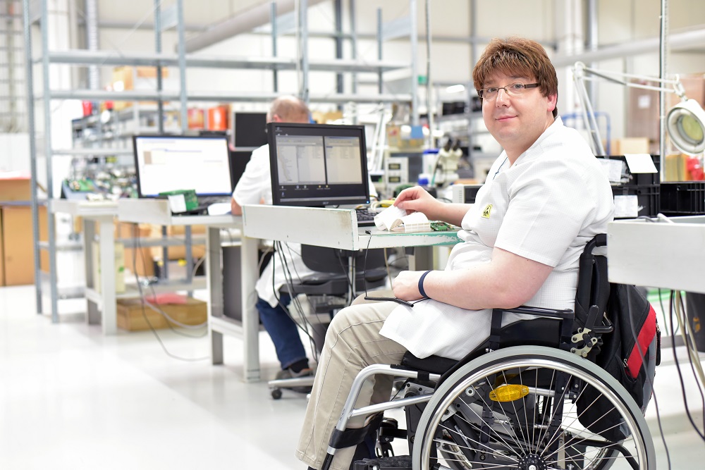 White Male in Wheelchair Working at Desk