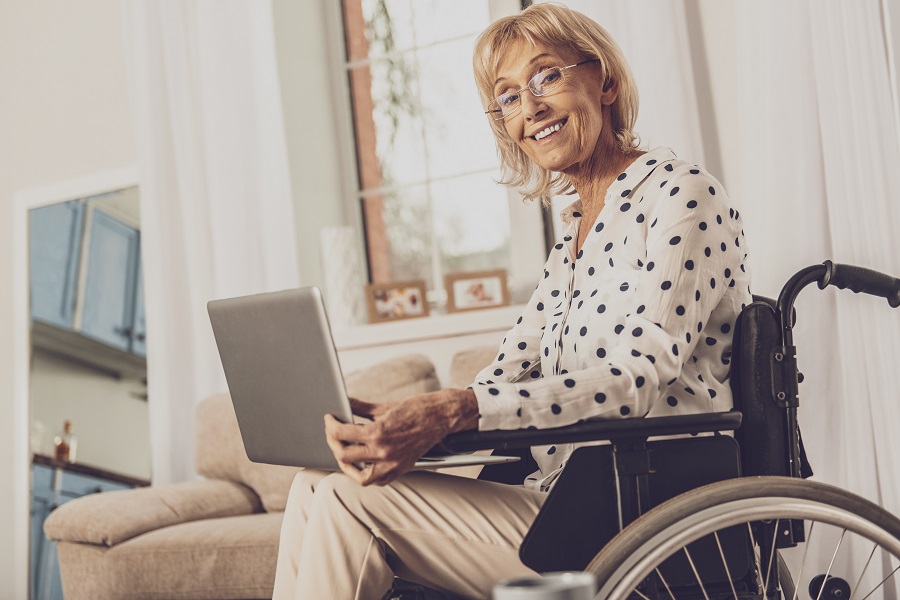 Elderly Lady in Wheelchair Working on Laptop