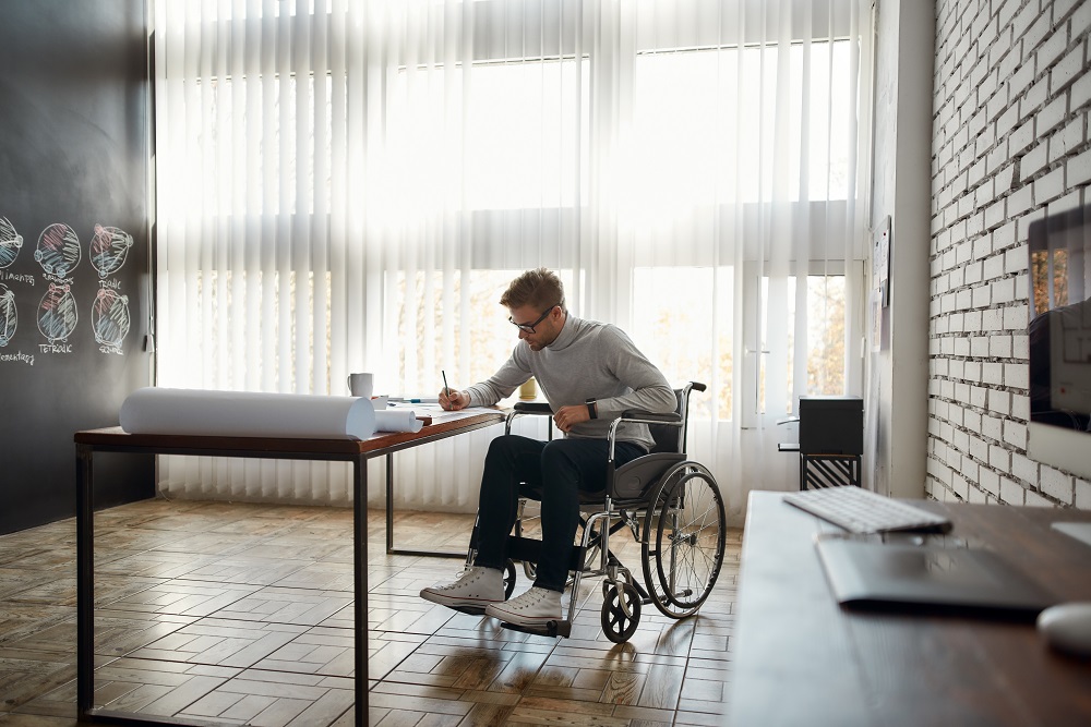 Man in Wheelchair Working at Desk